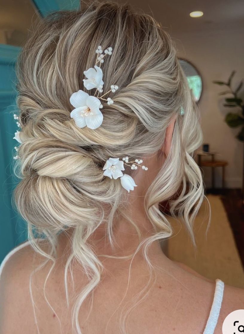 Ethereal textured low bun with scattered pearl and floral hairpins.