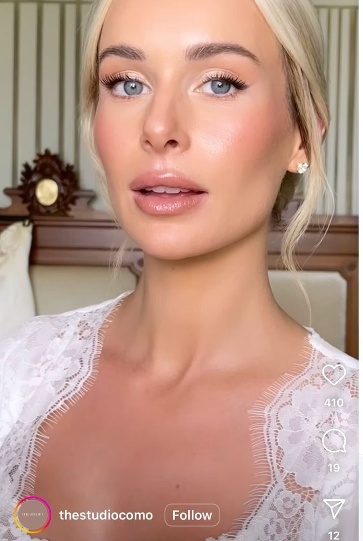 Bride with blonde hair in a lace robe featuring a natural dewy glam look.