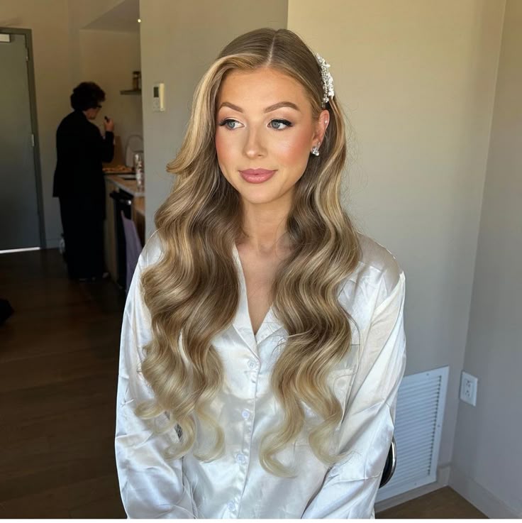 Woman with honey blonde Hollywood waves and a jeweled hair accessory.
