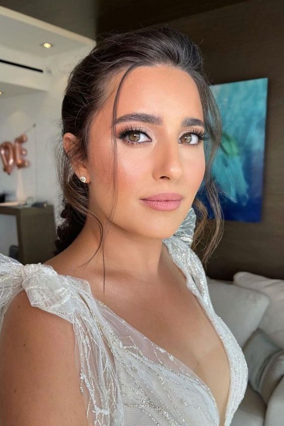 Woman with matte mauve makeup and elegant bridal guest styling.