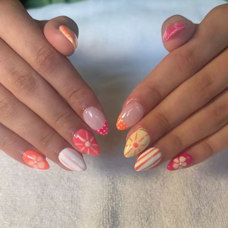 Short almond shaped nails decorated with various summer designs including orange stripes, yellow sunbursts, pink polka dot French tips, and simple flowers.