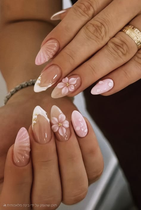 Almond shaped nails with a mix of light pink 3D seashell textures, white French tips with tiny pearls, and accent nails with raised 3D pink flowers and water droplets.