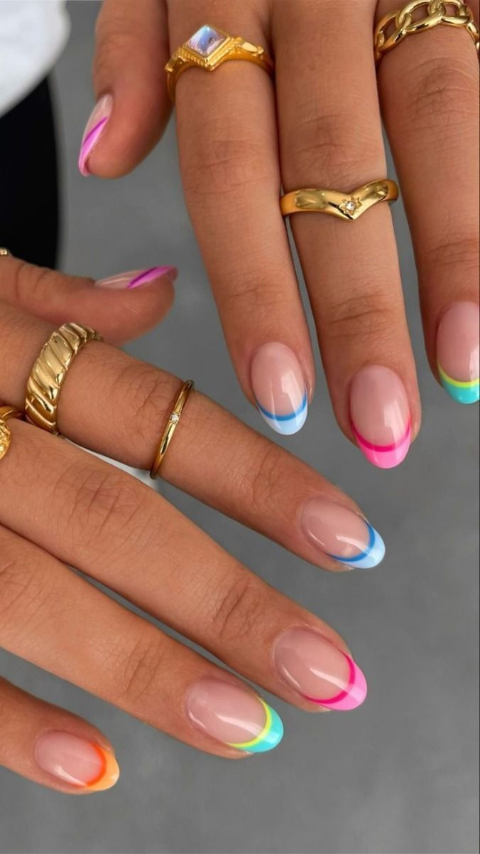 Almond shaped nails with a clean base featuring a double French tip design in pastel pink, blue, and yellow.