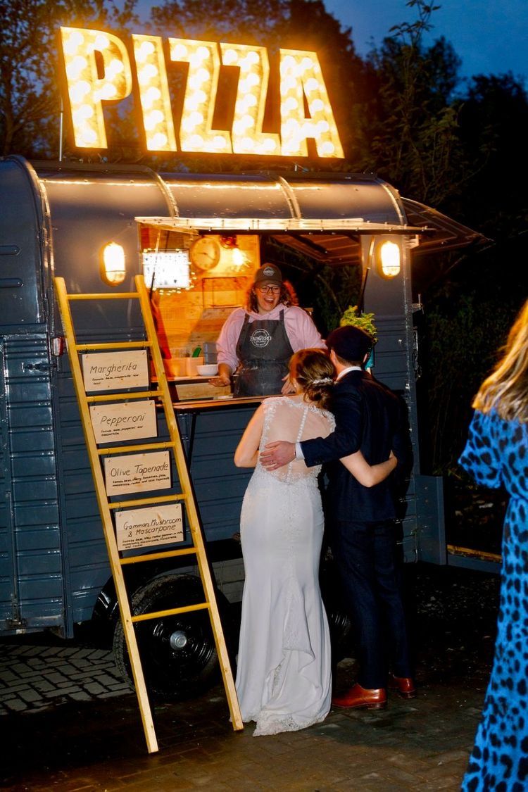 Mobile pizza wagon serving late-night food at an outdoor wedding reception.