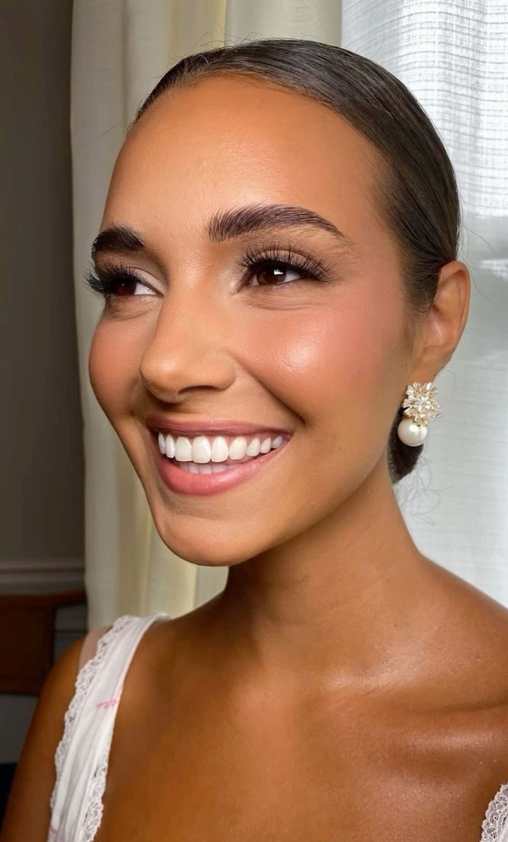 Close-up of bridal makeup for brown eyes featuring soft bronze eyeshadow and a neutral lip color. 
