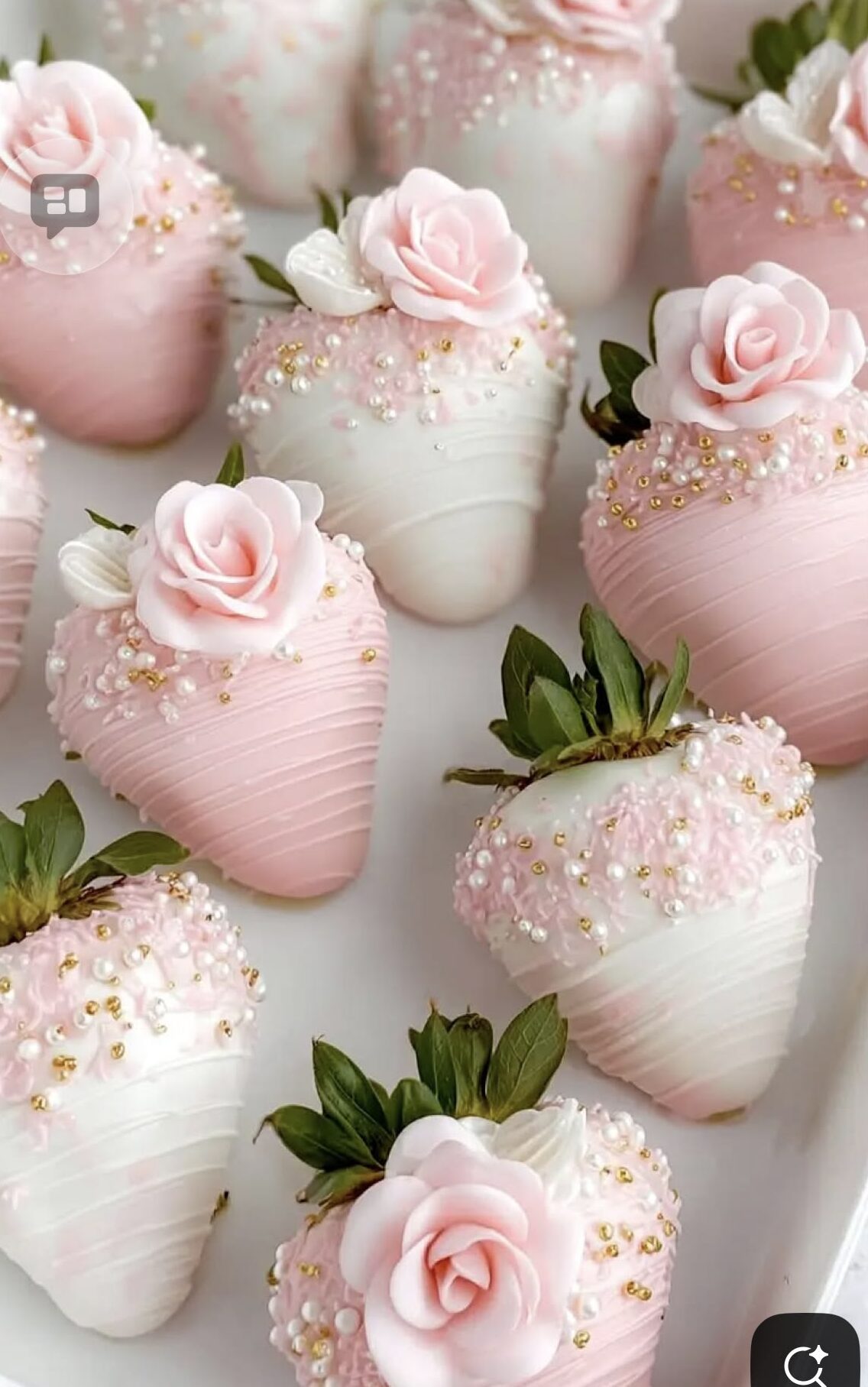 Chocolate-dipped strawberries decorated with pearls, gold accents, and edible flowers on a serving tray.
