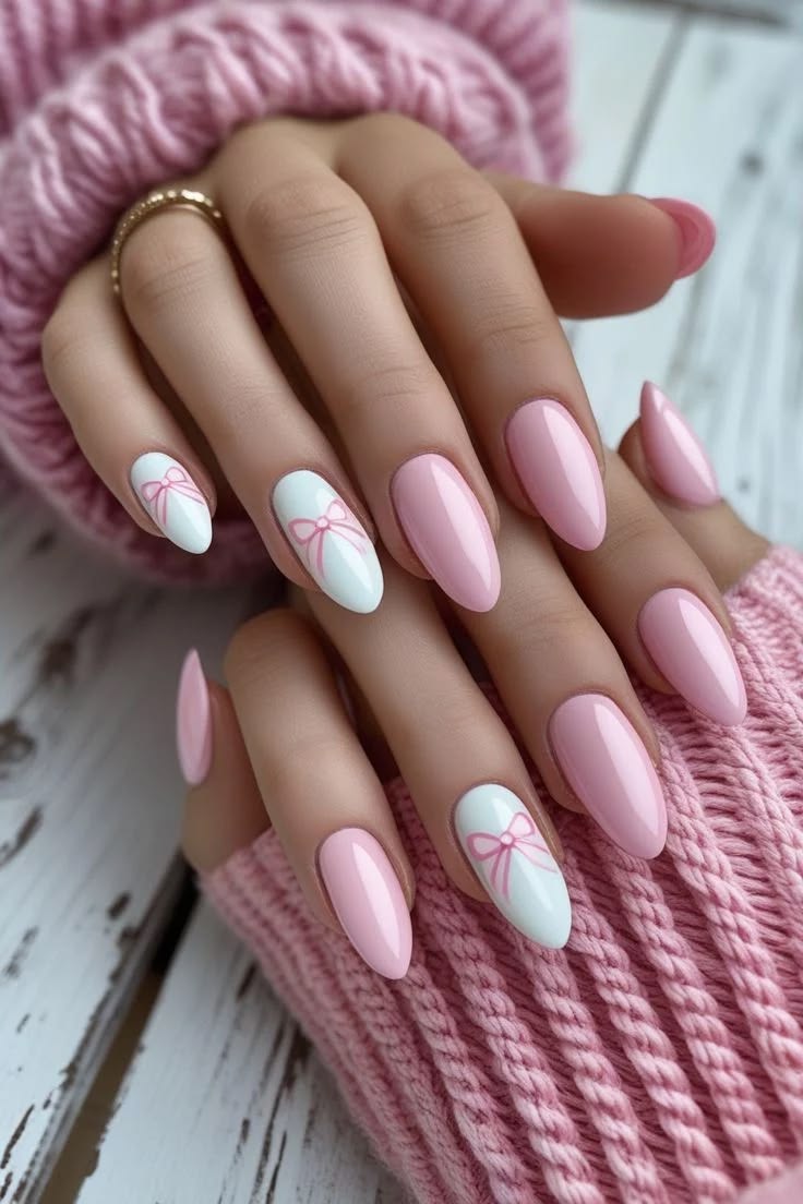 Romantic pink nails paired with white accent nails and hand-painted pink coquette bows.
