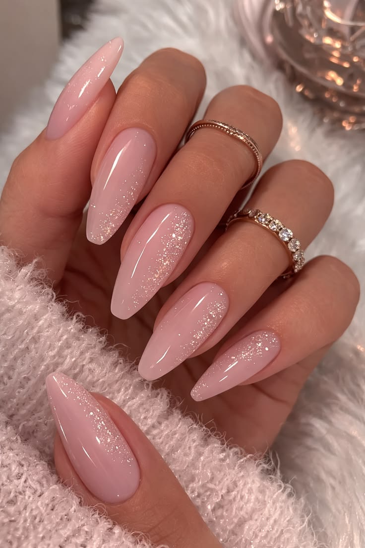 Elegant long almond nails featuring a soft pink base and a cascading champagne glitter ombre.