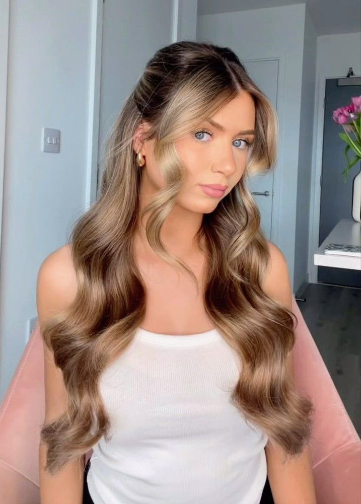 Bride wearing long warm brunette and blonde half-up waves with curled face-framing pieces
