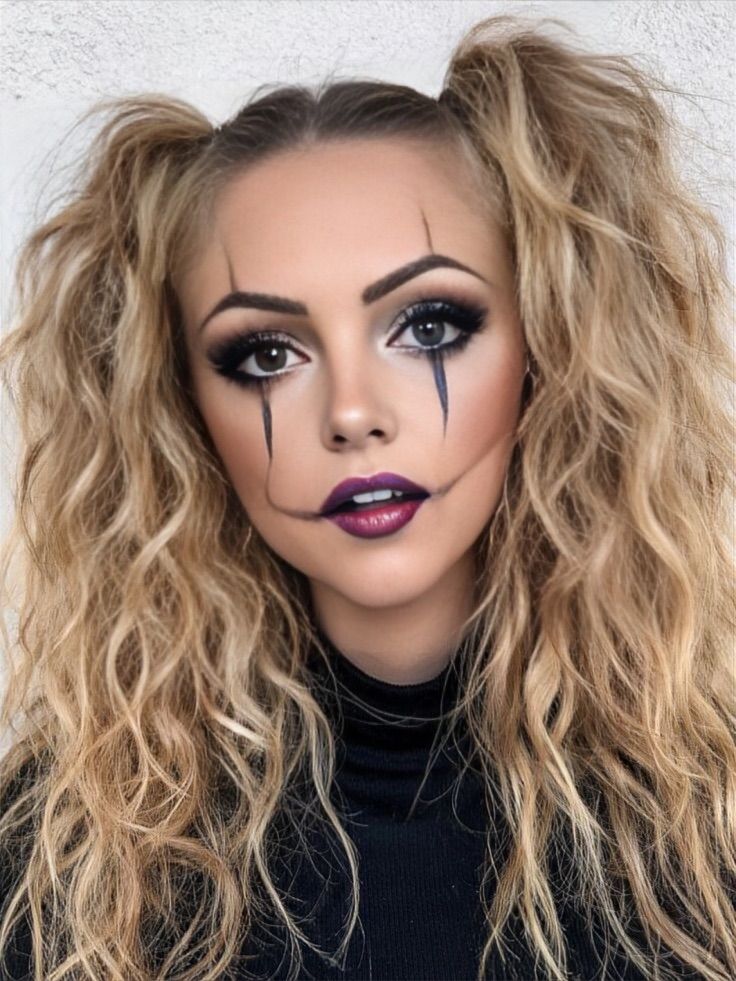 Woman wearing Pierrot clown Halloween makeup with black eye lines, dramatic lips and high pigtails