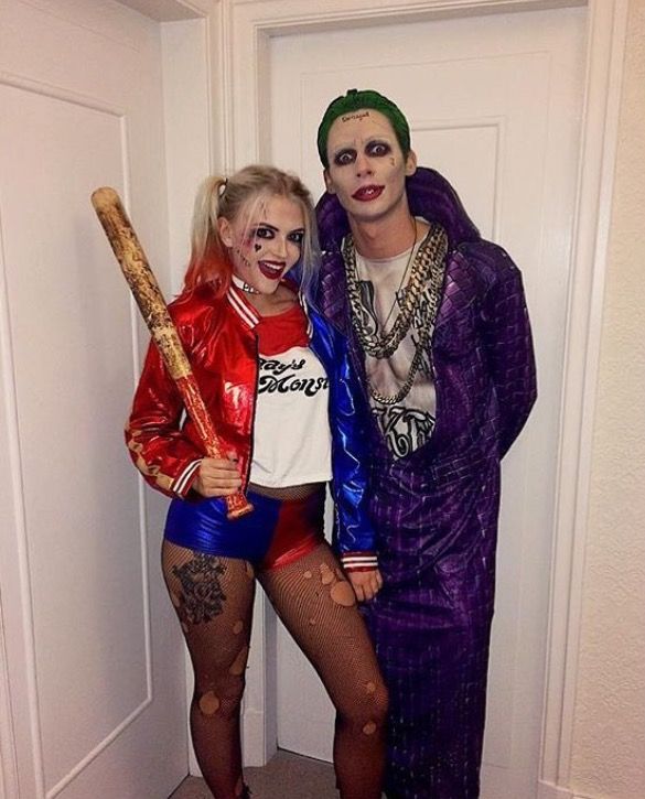 Couple in colorful comic book villain costumes with split dye pigtails and a baseball bat 
