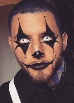 Man wearing sharp black star clown eye makeup with white contact lenses 
