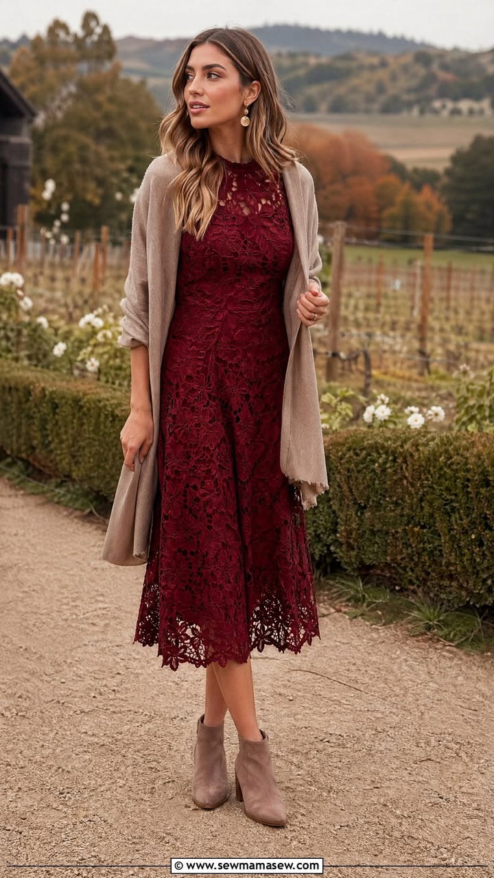 Woman wearing a burgundy lace midi dress with a neutral wrap at a vineyard wedding setting 
