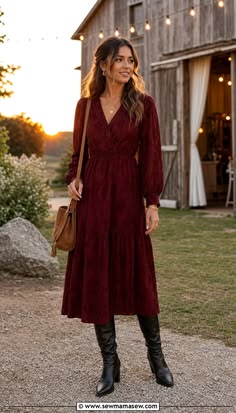 Woman wearing a burgundy long sleeve midi dress with black boots at a rustic barn wedding
